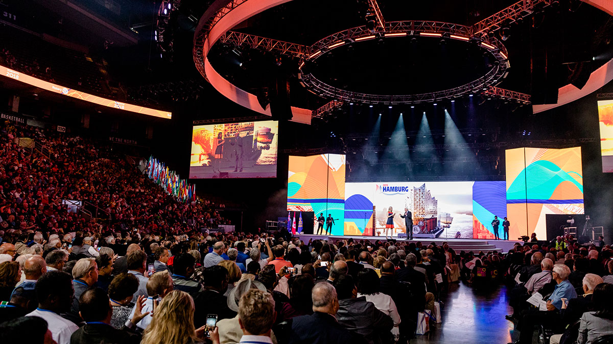 In una grande arena al coperto è in corso la sessione generale della Convention del Rotary International.